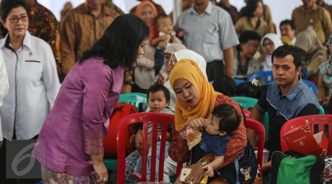 Ibu Negara, Iriana Widodo berbincang dengan warga saat menyambangi Puskesmas Ciracas, Jakarta, Senin (18/7). Iriana Widodo datang untuk memantau pemberian vaksin ulang terhadap anak-anak yang dulunya diberikan vaksin palsu. (Liputan6.com/Faizal Fanani)