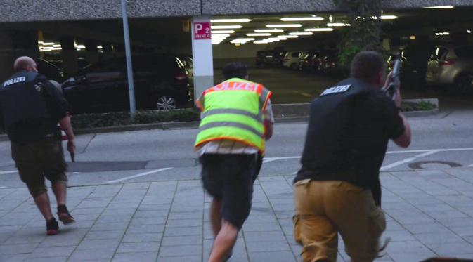 Petugas polisi Jerman berlari memasuki pusat perbelanjaan Olympia untuk memburu pelaku penembakan di Munich, Jerman (22/7). Penembakan ini hanya berselang tiga hari setelah terjadinya penyerangan di kereta api Jerman. (dedinac/Marc Mueller/REUTERS)