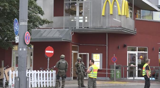 Petugas kepolisian saat mensterilkan kawasan sekitar pusat perbelanjaan Olympia, Munich, Jerman (22/7). Penyerang mulai melepas tembakan pukul 05.50 sore di gerai makanan cepat saji McDonald yang berada di seberang Olympia. (dedinac/Marc Mueller/REUTERS)