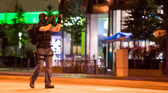 Seorang polisi mengamankan daerah sekitar pusat perbelanjaan Olympia Einkaufzentrum OEZ di Munich, Jerman (22/7). Pusat perbelanjaan ini berada di samping stadion Munich Olympic. (AFP PHOTO/Stringer)