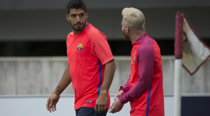 Luis Suarez dan Messi berbincang pada sesi latihan jelang laga melawan Celtic pada ajang International Champions Cup 2016 di St George's Park, Inggris (25/7/2016). (AFP/Oli Scarff).
