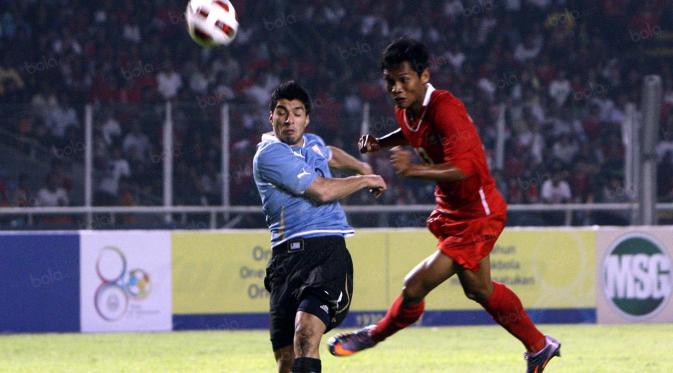 Luiz Suarez berebut bola dengan pemain Indonesia, Yongki Ariwibowo saat pertandingan Indonesia vs Uruguay di Senayan,Jakarta(8/8). Indonesia kalah 1-7. (Bola.com/Nicklas Hanoatubun)