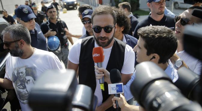 Sejumlah wartawan saat bertanya ke Gonzalo Higuain saat tiba di Juventus Medical Center, Italia (27/7). Mantan striker Napoli ini menjadi pemain kelima yang bergabung dengan Juve pada musim panas ini. (AFP PHOTO/MARCO BERTORELLO)