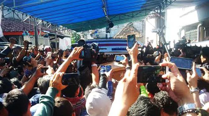 Mobil jenazah dan rombongan keluarga terpidana mati Freddy Budiman ditunggu warga di sepanjang jalan kawasan Krembangan Baru, Surabaya, Jawa Timur. (Liputan6.com/Dhimas Prasaja)