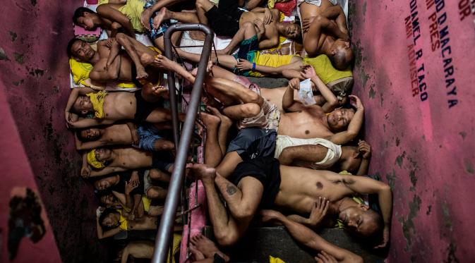 Sejumlah narapidana tidur berdesakan di tangga yang berada di dalam penjara Quezon City di Manila, Filipina, 19 Juli 2016. Setiap sel yang diperuntukkan untuk 20 tahanan, dihuni antara 160-200 tahanan dan harus berbagi ruang secara adil. (Noel Celis/AFP)