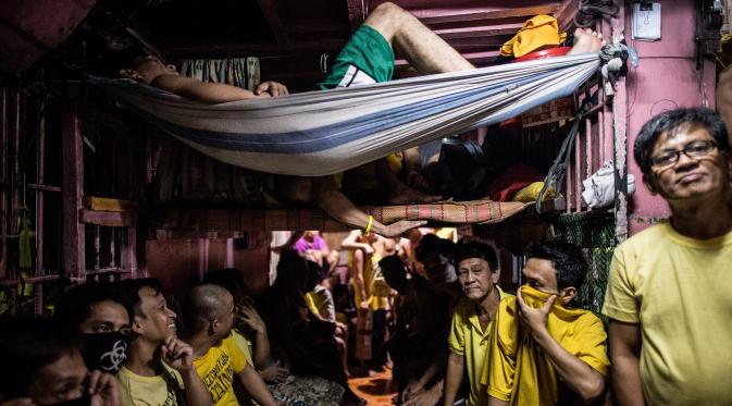 Seorang narapidana menggunakan selimut lusuhnya menjadi tempat tidur gantung di penjara Quezon City di Manila, Filipina, 18 Juli 2016. Para tahanan di penjara Quezon City juga menggunakan satu ruangan yang difungsikan serba guna. (Noel Celis/AFP)