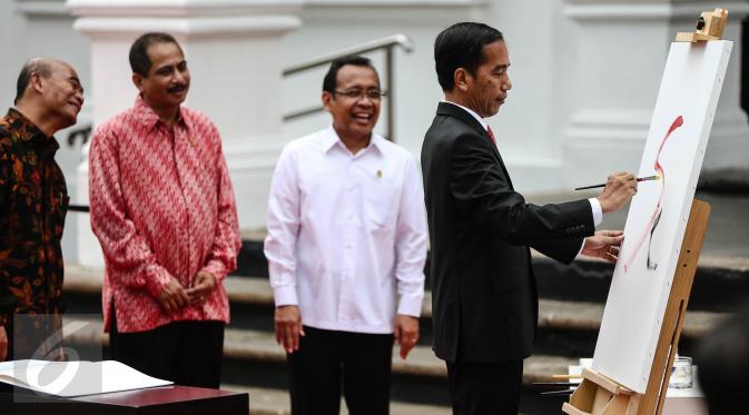 Presiden Jokowi menggores kuas di kanvas putih sebagai tanda dibukanya pameran seni rupa koleksi Istana Kepresidenan RI bertajuk ‘17:71 Goresan Perjuangan’ di Galeri Nasional, Jakarta, Senin (1/8). (Liputan6.com/Faizal Fanani)