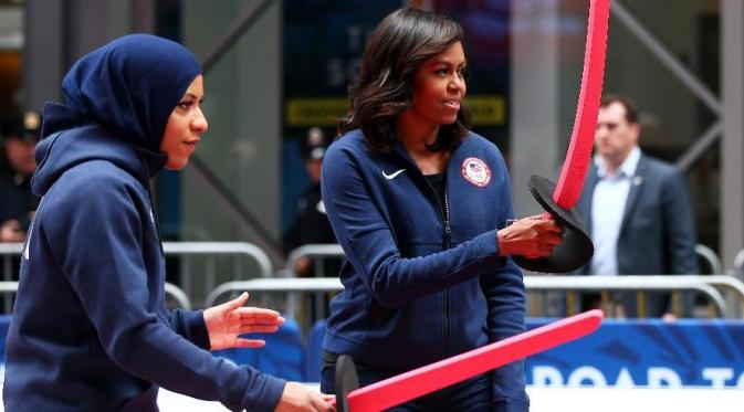 Atlet anggar, Ibtihaj Muhammad, mengajari Michele Obama bermain anggar, pada 27 April 2016. (Forbes)