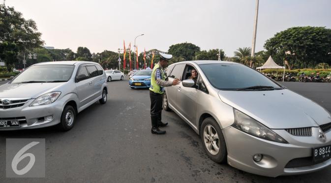 Petugas Kepolisian melakukan pencatatan jumlah mobil yang melanggar di Jalan Medan Merdeka Barat, Jakarta, Jumat (5/8). Terhitung 27 Juli hingga 3 Agustus 2016 jumlah pelanggaran uji coba ganjil-genap mencapai 5.947 pelanggar. (Liputan6.com/Yoppy Renato)