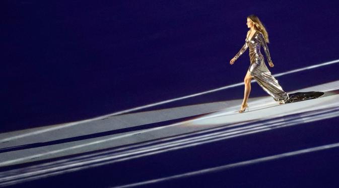 Model seksi asal Brazil Gisele Bundchen berjalan di atas panggung dengan gaun mengkilapnya saat mengambil bagian dalam upacara pembukaan Olimpiade Rio 2016, Rio de Janeiro, Brasil, (5/8). (REUTERS / Mike Blake)