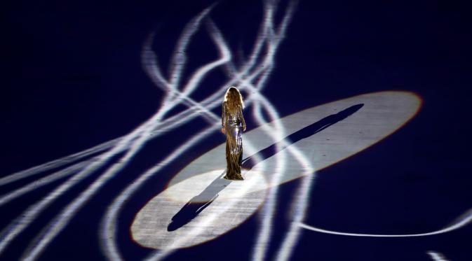 Dengan lampu yang memukau Model Gisele Bundchen berjalan di atas panggung dengan gaun mengkilapnya di upacara pembukaan Olimpiade Rio 2016, Rio de Janeiro, Brasil, (5/8). (REUTERS / Mike Blake)