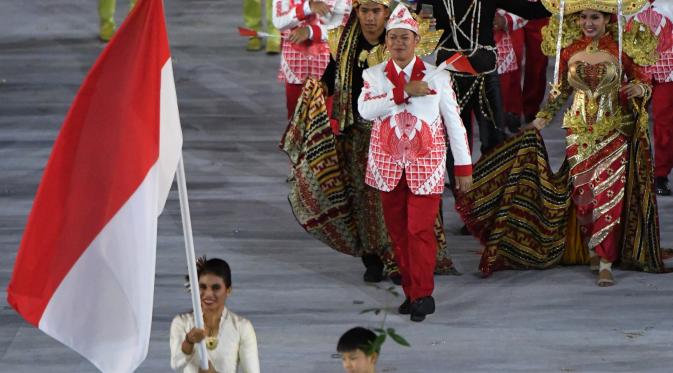 Kontingen atlet Indonesia saat parade upacara pembukaan Olimpiade 2016 di Stadion Maracana, Rio de Janeiro, Brasil (5/8). Kostum Indonesia yang didesain Prima Suci Ariani tersebut kali pertama diperkenalkan pada 15 Juli 2016. (PEDRO UGARTE / AFP)