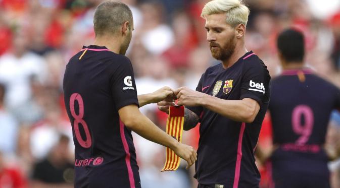 Lionel Messi tampak lesu dan berikan ban kapten kepada Andres Iniesta di Liverpool vs Barcelona (reuters)