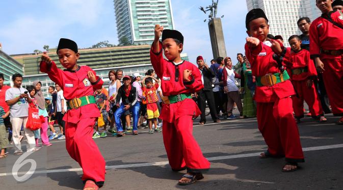 Tiga pendekar cilik memeragakan gerakan pencak silat di Jakarta, Minggu (7/8). Sekitar 1000 pendekar memadati Bundaran HI untuk merayakan Lebaran Pendekar Betawi 2016. (Liputan6.com/Angga