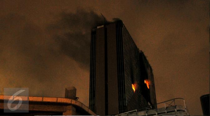 Api menyala di sekitar lantai 23 bangunan Gedung Swiss Belhotel, Kelapa Gading, Jakarta, Minggu (7/8). Dua pekerja dikabarkan tewas saat terjadi kebakaran di hotel yang masih dalam tahap penyelesaian. (Liputan6.com/Helmi Fithriansyah)