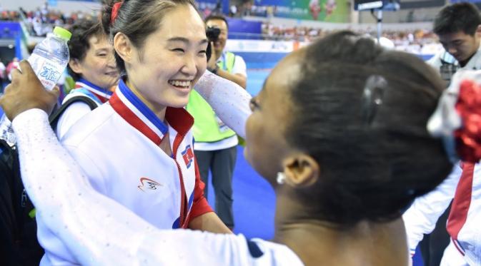 Pesenam Korut Hong Un-jong berpelukan dengan atlet AS (AFP)