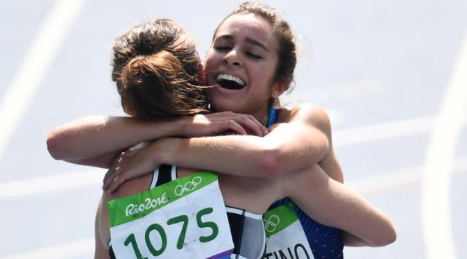 Abbey D'agostino memeluk Nikki Hamblin usai finish pada ajang lari 5000m putri Olimpiade Rio 2016 di Olympic  Stadium, Rio de Janeiro, (16/8/2016). (AFP/Pedro Ugarte)