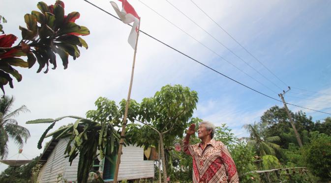 Eks tapol PKI, Sugito Kasirin memberi hormat pada bendera merah putih. (Liputan6.com/Abelda Gunawan)
