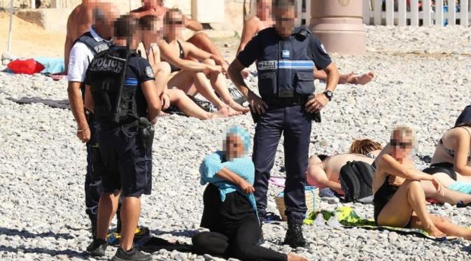Foto polisi menjatuhkan denda pada perempuan yang mengenakan burkini memicu kontroversi di Prancis (CNN)