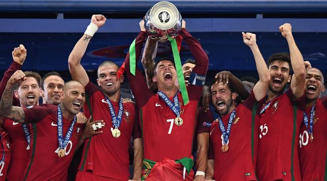 Bintang Portugal, Cristiano Ronaldo, mengangkat trophy Piala Eropa usai menaklukkan Prancis 1-0 pada laga final. CR 7 dan kawan-kawan berhasil untuk pertama kalinya mempersembahkan Portugal gelar Piala Eropa. (AFP/Franck Fife)