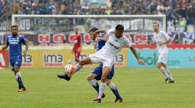 Raphael Maitimo (putih) berduel dengan Robertino Pugliara pada partai Persib vs Arema di Stadion Si Jalak Harupat, Bandung, Sabtu (27/8/2016). (Bola.com/Nicklas Hanoatubun)