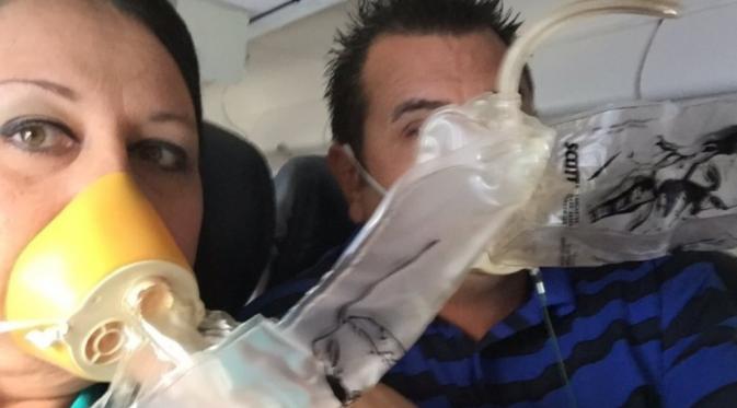 Penumpang mengenakkan masker pernapasan saat pesawat mulai turun (Twitter/CNN)