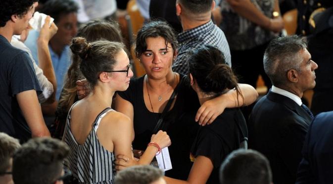 Keluarga korban tewas menangis dan saling berpelukan mengiringi kepergian orang terkasih mereka (Reuters)