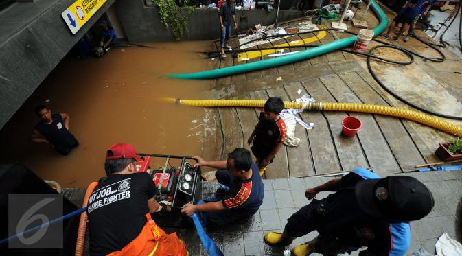 Petugas Damkar PB menyalakan mesin penyedot air saat melakukan pengeringan di salah satu pertokoan di Jalan Kemang Raya, Jakarta, Minggu (28/8). Dua lokasi parkir bawah tanah pertokoan di kawasan Kemang terendam air. (Liputan6.com/Helmi Fithriansyah)