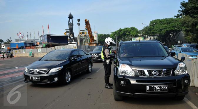 Petugas menjelaskan aturan sistem ganjil genap kepada pengendara mobil yang melintas di Bundaran Senayan, Jakarta, Rabu (31/8). Sejak kemarin mulai diberlakukan sanksi kepada pengendara yang melanggar aturan ganjil-genap. (Liputan6.com/Gempur M Surya)