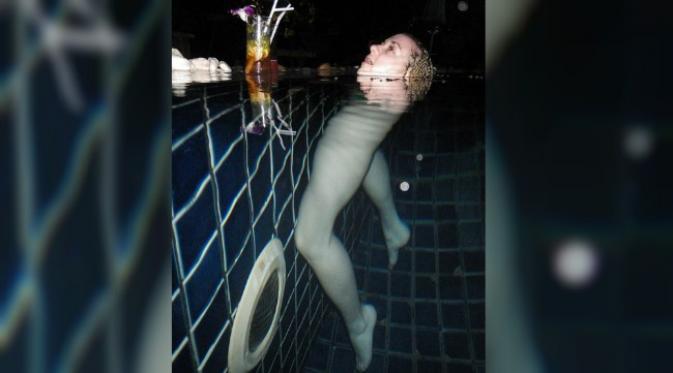 Salah satu ilusi optikal terkini. Seorang wanita dalam kolam renang seakan tidak memiliki tubuh. (Sumber Imgur via Daily Mail)