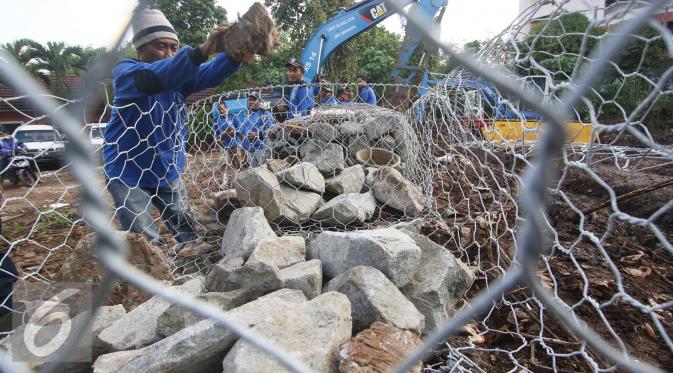 Dinas Tata Air DKI Jakarta memasang bronjong yang baru terpasang sekitar 10 meter dengan ketinggian setengah meter untuk menggantikan tembok yang ambrol saat banjir Sabtu lalu, Kemang, Jakarta, Rabu (31/8). (Liputan6.com/Immanuel Antonius)