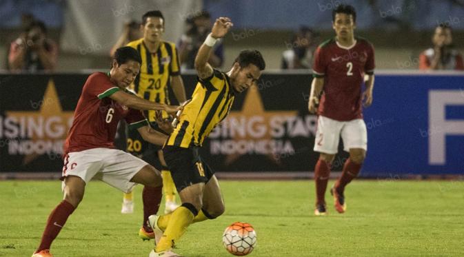 Gelandang Indonesia, Evan Dimas, berusaha merebut bola dari gelandang Malaysia, Zack Haikal. Pertandingan ini merupakan laga perdana Indonesia pasca terbebas dari sanksi FIFA, Selasa (6/9/2016). Indonesia menang 3-0. (Bola.com/Vitalis Yogi Trisna)