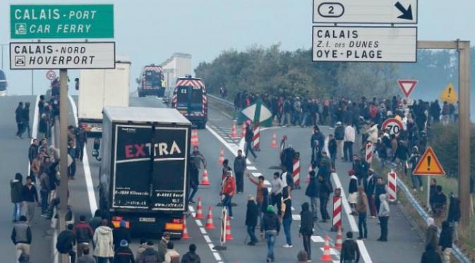 Para migran di Calais berupaya untuk menyeberang ke Inggris dengan mencegat truk dan menaikinya