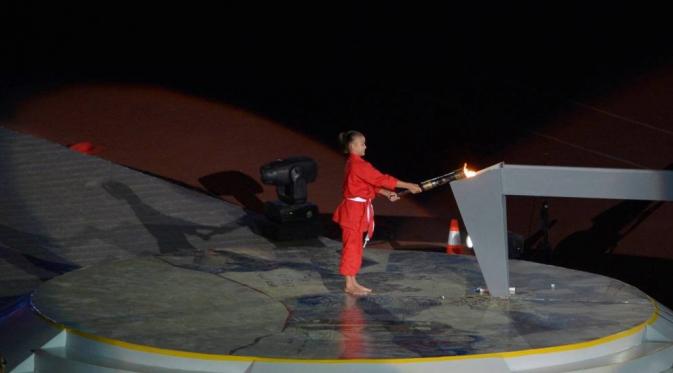 Karateka cilik, Lala Diah Pitaloka, menyulut api di kaldron pada pembukaan PON 2016 di Stadion Gelora Bandung Lautan Api (GBLA), Sabtu (17/9/2016). (pon-peparnas2016jabar.go.id)