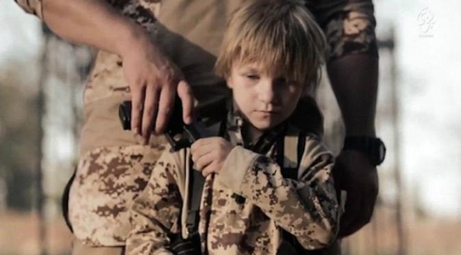 Seorang bocah berambut pirang dan berwajah bak malaikat dipaksa militan ISIS untuk menembak seorang tawanan di Irak (Daily Mail)