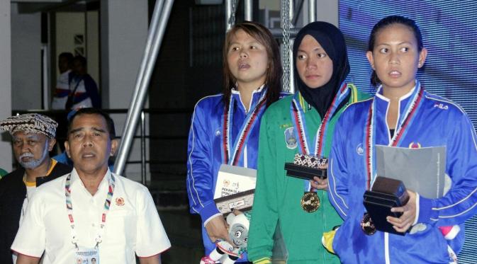 Perenang Jatim, Adinda Larasati (berjilbab), menyabet medali emas dari nomor 200 meter gaya kupu-kupu putri PON Jabar 2016, Selasa (20/9/2016). (Bola.com/Fahrizal Arnas)
