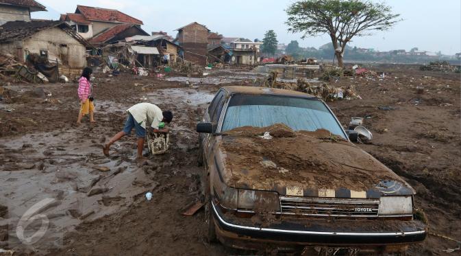 Sebuah mobil tertutup lumpur akibat banjir bandang di Kampung Cimacan, Kecamatan Tarogong, Kabupaten Garut, Kamis (22/9). Berdasarkan data sementara Basarnas Jabar 57 rumah hanyut dan 633 rumah terendam serta 59 orang luka-luka. (Liputan6.com/Johan Tallo)