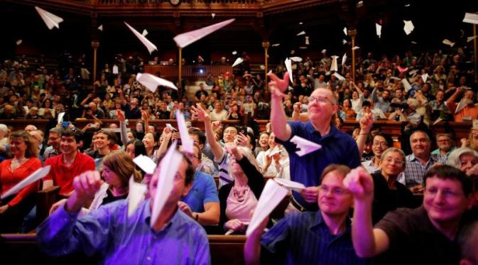 Hadirin penganugerahan Ig Nobel 2016 di Harvard University melemparkan pesawat kertas (Reuters)