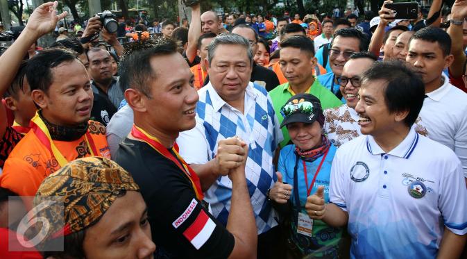 Calon Gubernur DKI Jakarta Agus Harimurti Yudhoyono melakukan salam komado dengan SBY saat menyapa warga Jakarta di Car Free Day (CFD), Senayan, Minggu (2/10). (Liputan6.com/Johan Tallo)