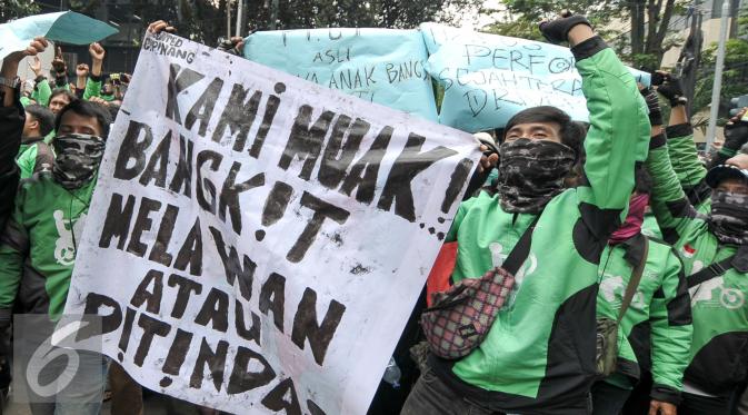 Massa driver Gojek membawa spanduk saat aksi protes ke kantor pusat mereka di Kemang, Senin (3/10). Ratusan pengemudi Gojek itu menuntut penghapusan sistem performa atau rating. (Liputan6.com/Yoppy Renato)