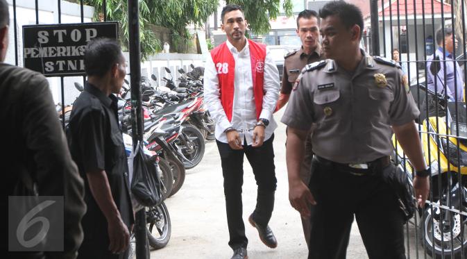 Aktor Restu Sinaga dengan tangan diborgol dan pengawalan petugas tiba di Pengadilan Negeri Jakarta Selatan, Kamis (13/10). Restu Sinaga akan menjalani sidang perdana atas kasus kepemilikan narkoba pada Juni lalu. (Liputan6.com/Herman Zakharia)