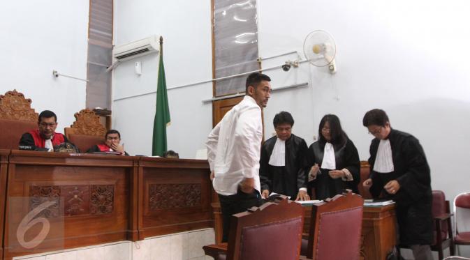 Aktor Restu Sinaga berdiskusi dengan kuasa hukumnya disela sidang perdana kasus narkoba di PN Jakarta Selatan, Kamis (13/10). Sebagaimana diketahui, Restu ditangkap pada Juni 2016 lalu karena kasus kepemilikan narkoba. (Liputan6.com/Herman Zakharia)