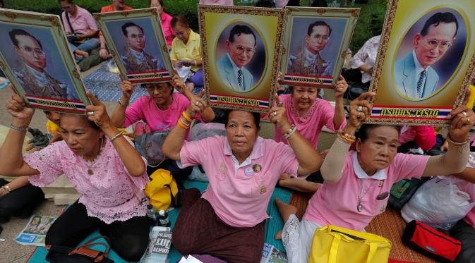 Warga berkumpul di Rumah Sakit Siriraj sambil membawa gambar Raja Thailand Bhumibol Adulyadej di Bangkok, Thailand, Kamis (13/10). Bhumibol meninggal dunia pada usia 88 tahun, setelah sakit dalam beberapa tahun terakhir. (Via: REUTERS / Chaiwat Subprasom)