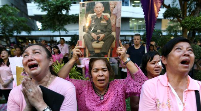 Warga membawa gambar Raja Thailand Bhumibol Adulyadej di RS Siriraj, Bangkok, Thailand, Kamis (13/10). Hingga akhir hayatnya, Raja Bhumibol Adulyadej merupakan raja yang paling lama berkuasa di dunia. (REUTERS / Chaiwat Subprasom)