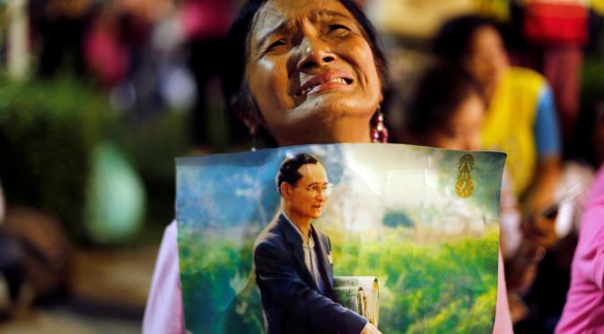 Seorang wanita menangis setelah diumumkan bahwa Raja Thailand Bhumibol Adulyadej telah meninggal di RS Siriraj, Bangkok, Thailand, Kamis (13/10). (REUTERS / Jorge Silva)