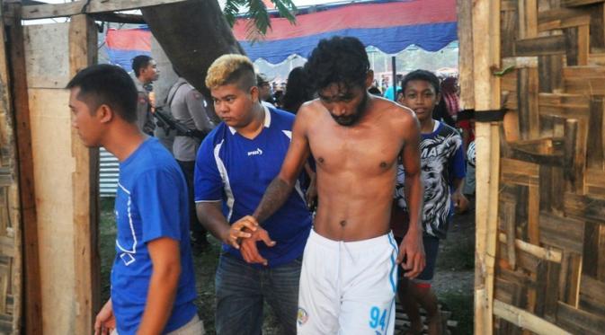 Ferry Aman Saragih terpaksa bertelanjang dada karena jersey Arema yang dipakainya dilucuti Aremania. (Bola.com/Iwan Setiawan)
