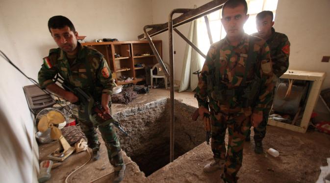 Tiga pasukan Peshmerga bersenjata berjaga di terowongan tempat persembunyian militan ISIS selama operasi penyerangan di Mosul, Irak (19/10). Penemuan terowongan milik militan ISIS itu terdapat di dalam bangunan. (REUTERS/Azad Lashkari)
