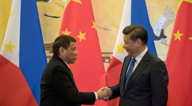 Presiden Filipina Rodrigo Duterte berjabat tangan dengan Presiden Xi Jinping seusai pertemuan dua negara di Beijing (20/10). Pertemuan tersebut membuat kebijakan luar negri Filipina yang lebih condong ke Tiongkok daripada ke AS. (Reuters/ Ng Han Guan)