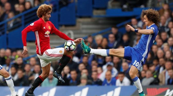    Pemain Chelsea, David Luiz (kanan), berebut bola dengan pemain Manchester United, Marouane Fellaini dalam sebuah duel di Liga Inggris. (Reuters/John Sibley)