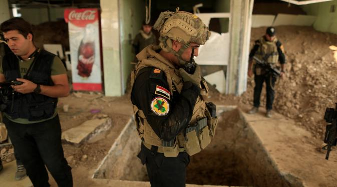 Sejumlah anggota pasukan khusus Irak berjaga di dekat terowongan yang digunakan oleh militan ISIS di dalam sebuah restoran di Bazwaya, Mosul, Irak (27/10). Sejumlah terowongan yang digunakan ISIS telah ditemukan di sekitar Mosul. (REUTERS/Zohra Bensemra)